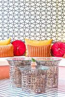 A colorful room with a couch, a table and a wall photo