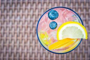 A colorful drink with blueberries and lemon slices photo