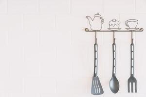 A kitchen utensil rack with three spoons and a fork photo