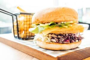 A large sandwich with a basket of fries on a table photo