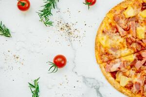 A pizza with ham, pineapple and tomatoes on a white background photo