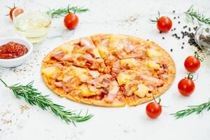 A pizza with ham, tomatoes and herbs on a white background photo
