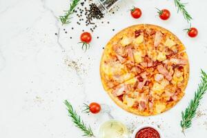 A pizza with ham, tomatoes and herbs on a white background photo