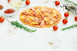 A pizza with ham, tomatoes and herbs on a white background photo