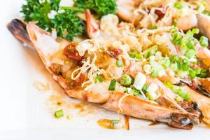 A plate of shrimp with green onions and sauce photo