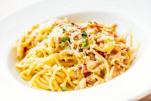 A plate of spaghetti with bacon and cheese photo