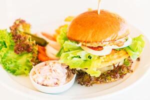 A plate with a burger and some vegetables on it photo