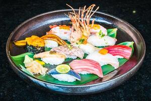 A plate of sushi on a table with a knife photo