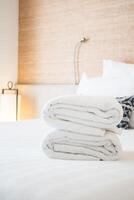 A stack of folded towels on a bed photo