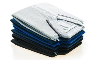 A stack of four different colored shirts photo