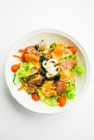A salad with salmon, tomatoes, onions and lettuce photo