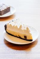 A slice of pie on a plate with a piece of cake next to it photo