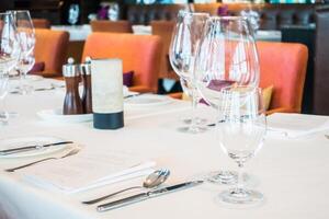 A table with a white cloth and a glass of wine photo