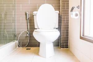 A toilet in a bathroom with a shower photo