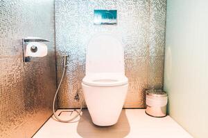 A toilet in a bathroom with a wall of mirrors photo