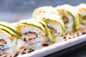 A sushi roll with avocado and chicken on it photo
