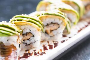 A sushi roll with avocado and chicken on it photo