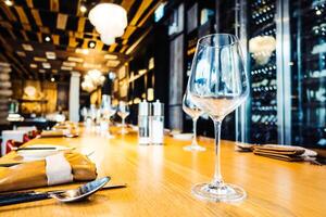 A table with wine glasses and silverware on it photo