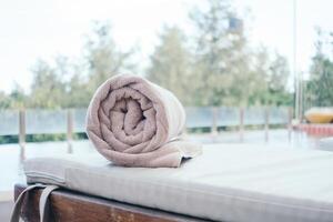 A towel is folded on top of a wooden bench photo