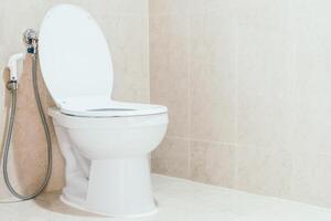 A toilet with a hose attached to it photo