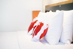 A white bed with red pillows and a red heart photo
