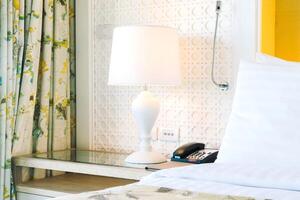A white bed with a lamp photo