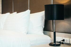 A white bed with two pillows and a lamp photo