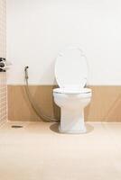 A white toilet sitting in a bathroom with a shower photo