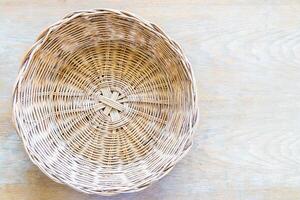 A wicker basket on a wooden table photo