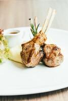 Grilled lamb chops on a white plate with mashed potatoes photo