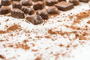 Chocolate candies scattered on a white surface photo