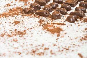 Chocolate candies scattered on a white surface photo