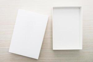 White box with blank card on wooden table photo