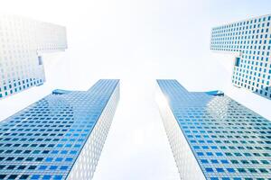 Two tall buildings with windows and sky in the background photo