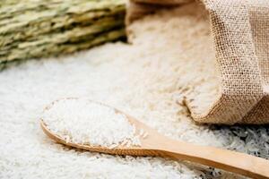 White rice in a sack and a wooden spoon photo