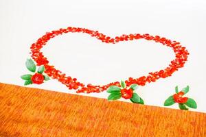 A heart shaped bed with red roses on it photo