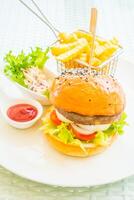 A hamburger and fries on a plate photo