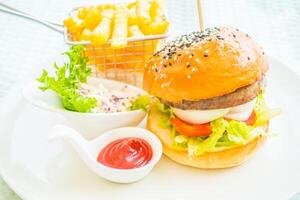A hamburger and fries on a plate photo