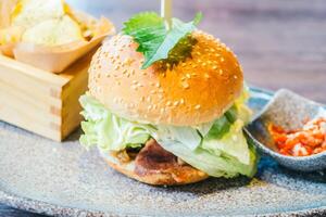 A hamburger with lettuce and tomato on a plate photo