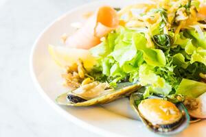 A plate of food with a salad and mussels photo