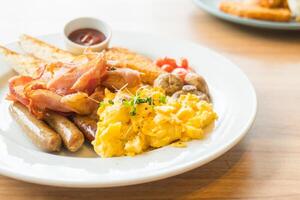 A plate of food with eggs, bacon, sausage and toast photo