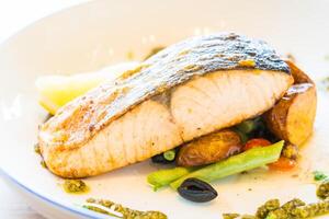 A plate of food with a piece of fish on it photo