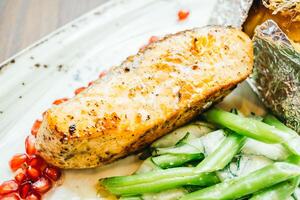 A plate of food with a piece of meat and some green beans photo
