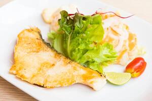 A plate with a fish and vegetables on it photo