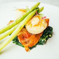 A plate with asparagus and scallops on it photo