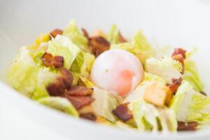 A salad with bacon and an egg in it photo