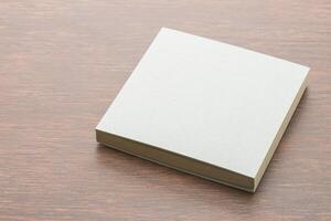 Blank white paper book on wooden table photo