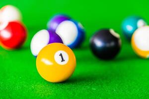 Billiards balls on green table with one ball in the middle photo