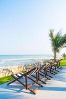 Beach chairs on the beach with palm trees photo