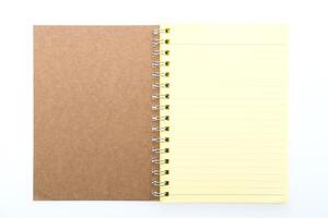A notebook with a yellow lined paper on a white background photo